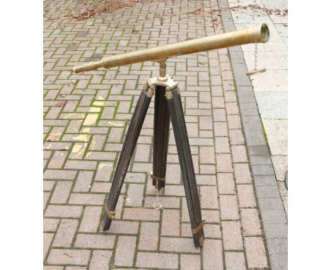 A replica 20th century brass telescope on wood tripod stand.