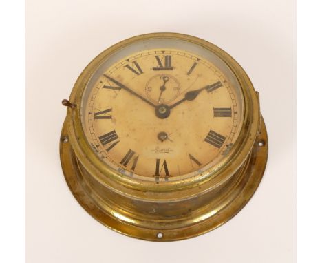 A mid 20th century English brass bulkhead clock by Sestrel, having painted dial with Roman numerals and subsidiary seconds di
