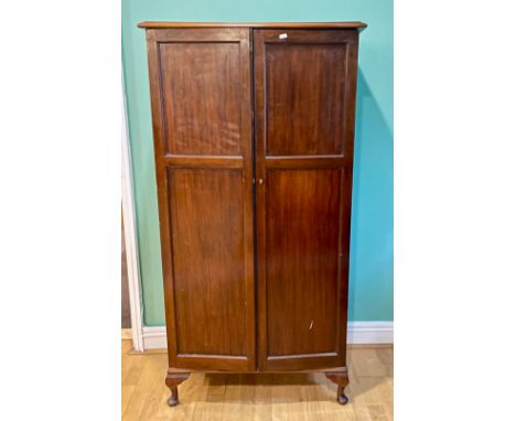 An Edwardian mahogany tall music cabinet, the twin panelled doors opening to fitted compartments containing ninety six harmon