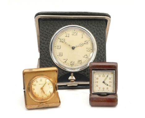 A Swiss travel clock, housed in a leather fold-out case, together with two miniature fold-out travel clocks, to include Newma