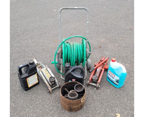 Two small  trolley jacks, garden hose reel on wheels, metal fly wheel, 5L auto cool, two x 5L engine oil.