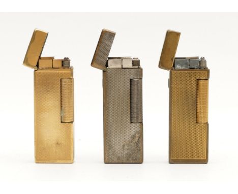 Alfred Dunhill; Two Dunhill gold plated rollagas cigarette lighters, having engine turned cases, together with a silver plate