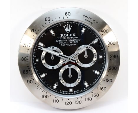 A 'Rolex' style advertising wall clock, black dial reads 'Rolex Oyster Perpetual Daytona' quartz movement, 34cm diameter.