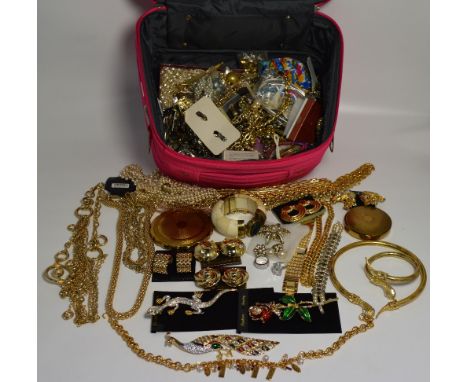 A vanity case of costume jewellery to include large enamel and diamanté brooches, earrings, chains etc.