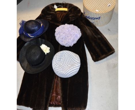A vintage faux fur coat and a hat box containing four vintage hats to include fabric and straw examples.