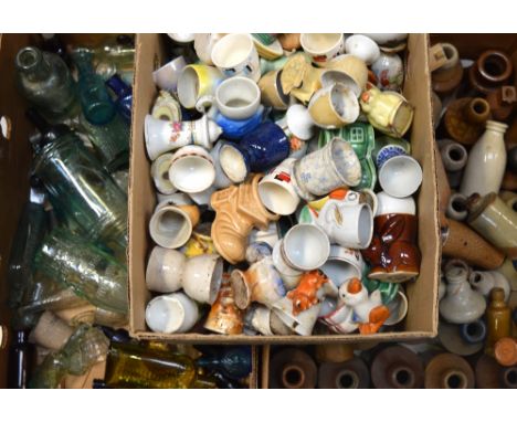 A quantity of stoneware bottles, glass bottles and ceramic, glass and wooden egg cups.