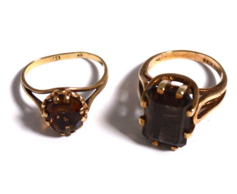 A 9ct gold dress ring set with a brown stone and a yellow metal dress ring set with an orange stone, approx combined weight 7