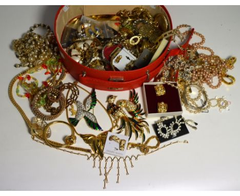 A red vanity case containing costume jewellery to include diamanté and enamel peacock brooches and bird brooches, earrings, n