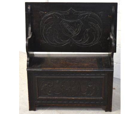 A 20th century stained oak monks bench with carved floral decoration, length 92cm.