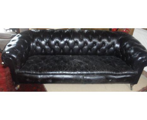 A late Victorian buttoned leather upholstered Chesterfield sofa on turned legs to brass caps and castors CONDITION REPORTS Le