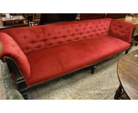 A Victorian mahogany framed show frame sofa, the buttoned upholstered back and arms over a plain upholstered seat, flanked by