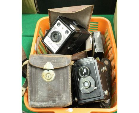 A basket of various vintage cameras including a Coronet Ambassador, a Voigtländer Brillant, a Kodak A-120, Pentax Espio 160, 