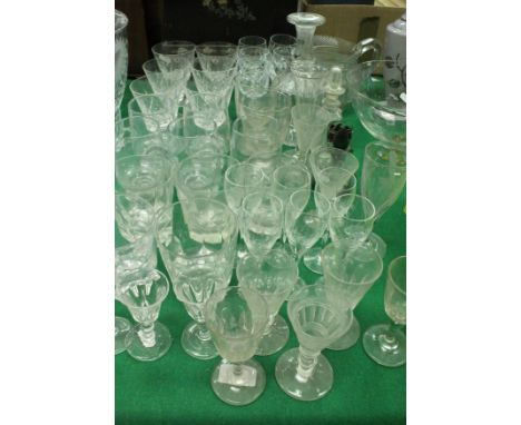 A collection of various glassware to include cut and other glass drinking glasses, decanter, small bottles and stoppers, etc