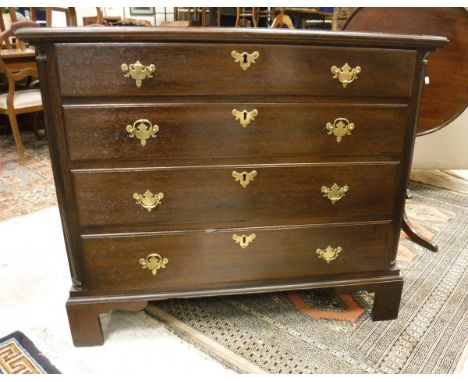 An oak chest in the George III manner of four long graduated drawers flanked by fluted quarter cut side pilasters on bracket 