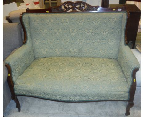 A Victorian mahogany two seat sofa with show frame and carved and pierced top rail, raised on cabriole legs to brass caps and