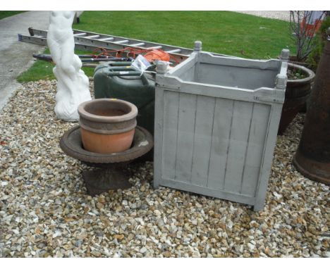 A painted wooden planter, a painted green petrol cans togther with a cast iron garden urn and a terracotta garden pot