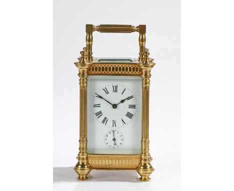 Late 19th Century French brass carriage clock, the reeded pilastered case with swing handle, the white enamel dial with Roman