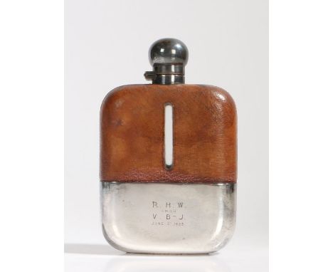 Early 20th Century silver plate and brown leather mounted glass hip flask, the plated bayonet fitting cap above a brown leath