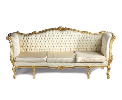 Continental gilt wood settee, with an undulating back carved with flowers above a button back and cushions flanked by high ar