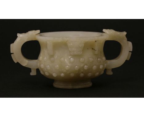 A Chinese jade two-handled cup,Ming dynasty (1368-1644), of circular form carved with studs, the handles and mouth with chilo