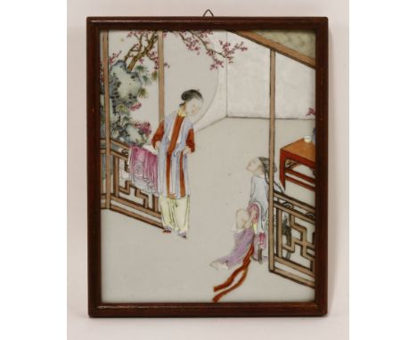 A Chinese famille rose ceramic plaque,Qianlong (1736-1795), painted with a couple putting their clothes on in an interior set