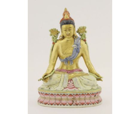 A Chinese famille rose bodhisattva,20th century, seated cross-legged on a double lotus pedestal, both hands holding the stem 