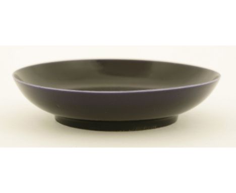 A Chinese saucer,18th century or later, of circular form under an aubergine glaze, six character Kangxi mark,11.6cm清十八世纪或更晚 茄