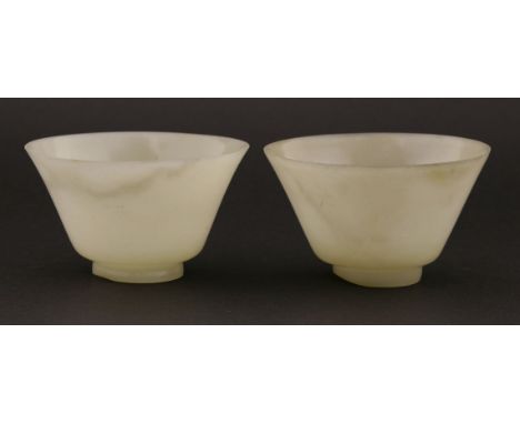 A pair of Chinese jade tea bowls, 20th century, of circular form with spared mouth, 9.2cm diameter (2)