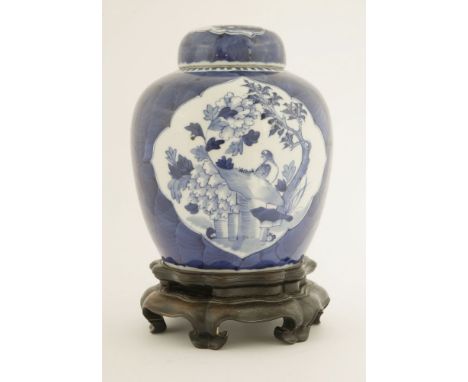A Chinese blue and white ginger jar and cover,late Qing dynasty, painted with a lady playing with a boy in a garden in a shap