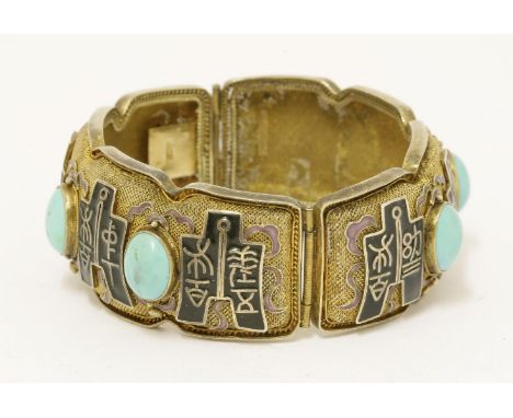 A Chinese silver gilt hinged bangle,1930s, the mesh ground enamelled with archaic characters on archaic coins, inset with tur
