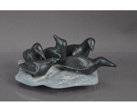 An Inuit carved stone sculpture group of five artic seabirds, the natural rock plinth forming 'waves'. Circa 1970's. Original