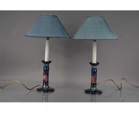 A pair of Moorcroft Pottery candlestick style lamps 20.5cm high, with baize bases, total hight including shades 52cm (2)