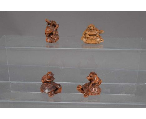Four Japanese carved wood netsuke, one as a turtle carrying a water buffalo, one a turtle carrying a pig and two with turtles