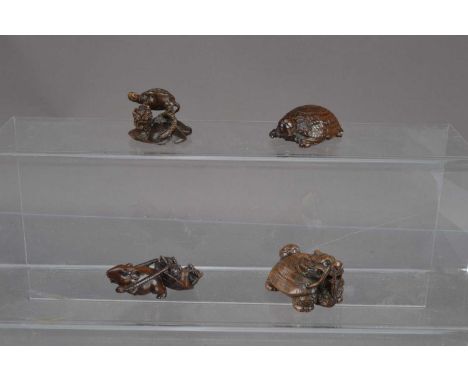 Four Japanese carved wood netsuke, one carved as a turtle, one as a rat pulling a turtle, one as a turtle on a lotus pad and 