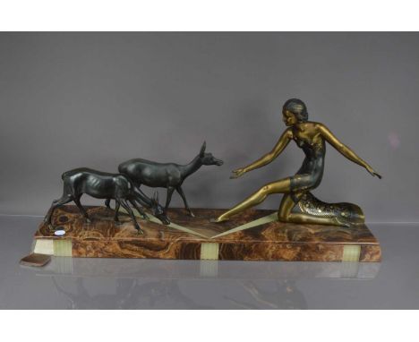 An Art Deco bronzed and marble figural group after Uriano, 92cm wide, having a female feeding two deer, one piece of marble l