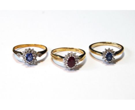 Two diamond and sapphire oval cluster rings and another, with ruby, in 9ct gold, sizes N, O and O½.CONDITION REPORT: Approxim