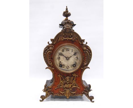 Continental fruitwood mantel clock with urn finial over vase-shaped trunk, gilt metal mounts, circular face, Arabic numerals,