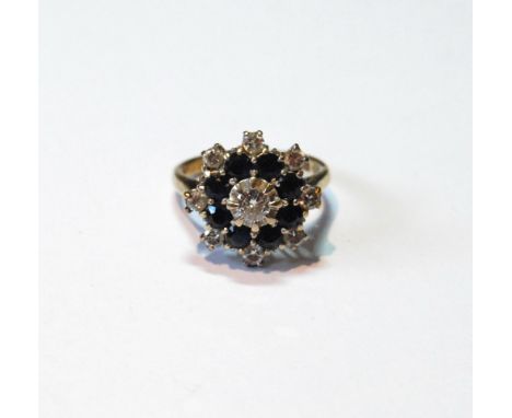 Cluster ring with diamond brilliant and eight sapphires within eight further brilliants, in 9ct gold, size L, 5.8g.