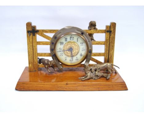 Early 20th century desk clock modelled as a fox and hounds over a gate, on an oak plinth base, with fusee movement, 16cm high