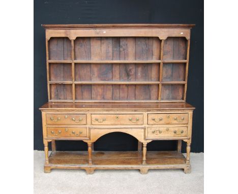 Georgian oak Welsh dresser, the projected moulded cornice over open shelves, moulded rectangular top over short drawers, rais