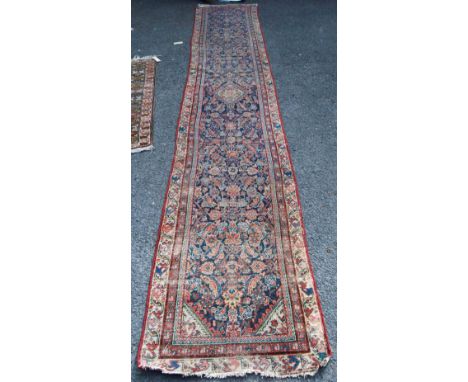 North west Persian runner with central diamond, all over floral pattern over blue ground and triple border, 460cm x 83cm. 