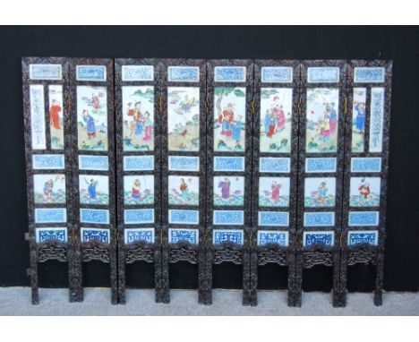 Chinese eight-fold hardwood screen, each fold set with six 19th century porcelain panels, the frame carved, 142cm wide and 10