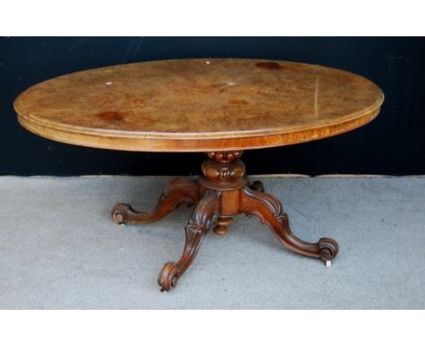 Victorian burr walnut looe table, the moulded oval top raised on gadrooned column, quad cabriole legs terminating in scrolls 