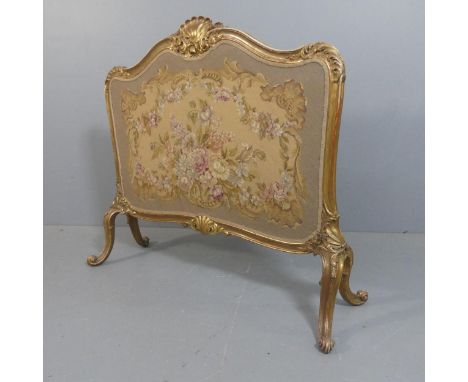 A French gilt painted firescreen with needlepoint upholstered panel, carved decoration and cabriole legs. Width 115cm, height