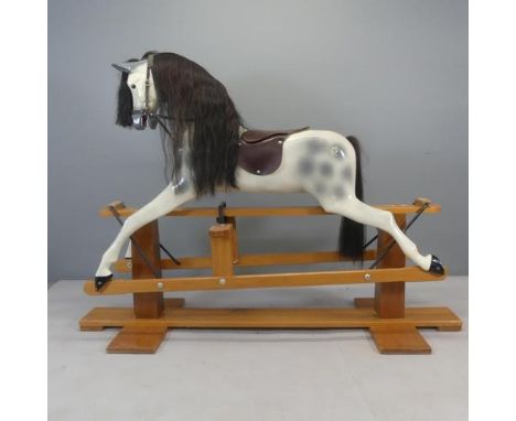 HADDON - A fibreglass rocking horse on a teak stand, with makers' label. Length 183cm, height 135cm, depth 60cm.