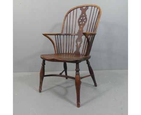 A 19th century elm-seated comb and wheel backed elbow chair, with crinoline stretcher.Repair visible to splat back, abrasions