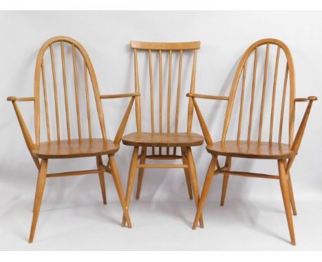 A pair of Ercol light elm carvers twinned with an earlier Ercol stick back chair, some staining to seat of centre chair &amp;