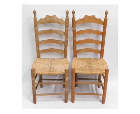 A pair of oak rush seat ladder back dining chairs, 42in high to back