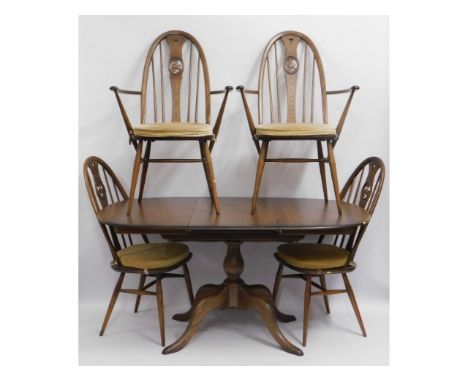 An extending Ercol elm table with two carvers &amp; two dining chairs, 59in wide extended