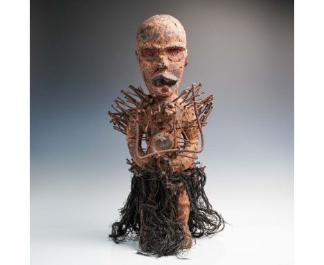 This dramatic carved wooden figure represents a traditional Nkisi Nkondi, or nail fetish figure, rooted in the spiritual prac